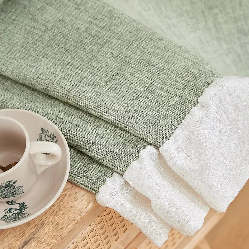 Serviette élégante aux tons vert et blanc, déposée sur une table en bois, avec une tasse décorative adjacente, idéale pour embellir votre espace de vie.