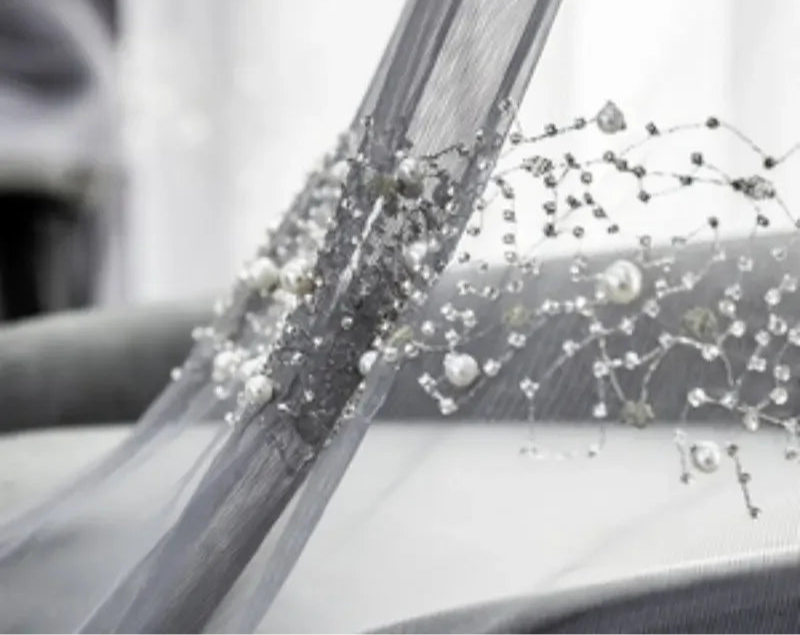 Voilage gris perlé délicat avec broderies et perles pour salon raffiné.