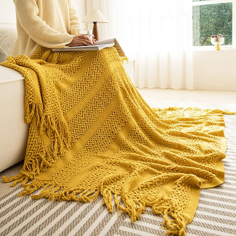 Une élégante couverture en tricot jaune moutarde apporte une touche de chaleur et de confort à l'espace intérieur.