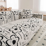 Canapé moelleux avec un motif floral noir et blanc, créant une ambiance élégante et chaleureuse dans le salon.