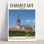 L'image présente une vue de la ville de Darmstadt, en Allemagne, avec son église emblématique à haut clocher au centre de la scène. La ville de Darmstadt est décrite comme un lieu cultivé et diversifié, avec un profil développé à travers les sciences, la littérature, l'art et l'architecture.