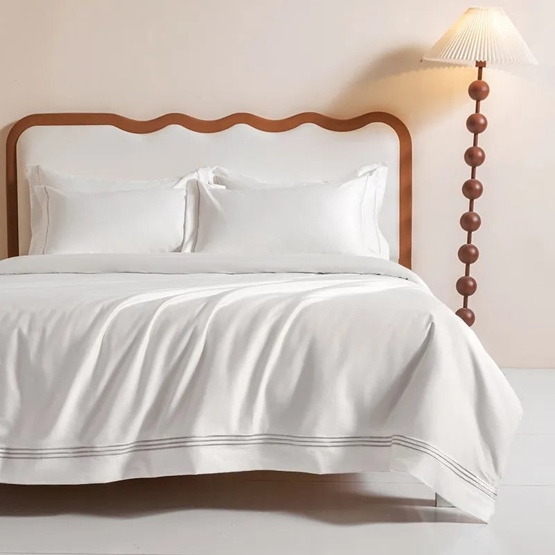Détail de la bordure brodée argentée sur housse de couette blanche