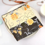 Napperon papier beige avec fleurs noires et roses sur table