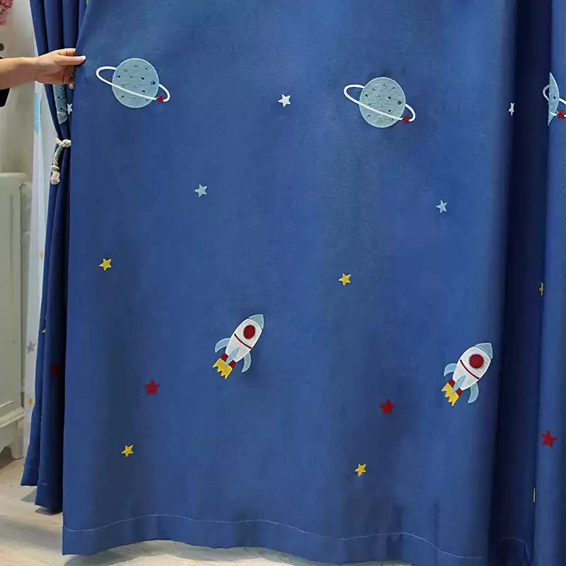Rideau bleu avec motifs spatiaux pour chambre d'enfant, orné de fusées et planètes. Idéal pour une décoration thématique sur l'espace apportant une touche ludique et éducative à la pièce. Accessoire parfait pour stimuler l'imagination des enfants tout en embellissant leur environnement.