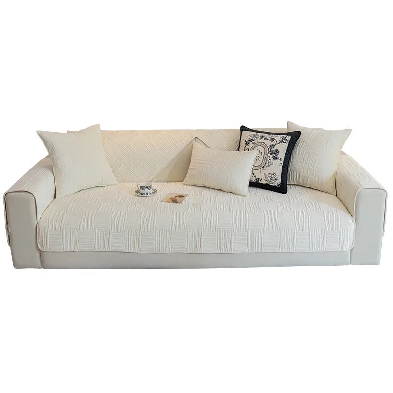 Ce canapé beige en tissu est doté de motifs texturés et de coussins décoratifs pour un style moderne et confortable.