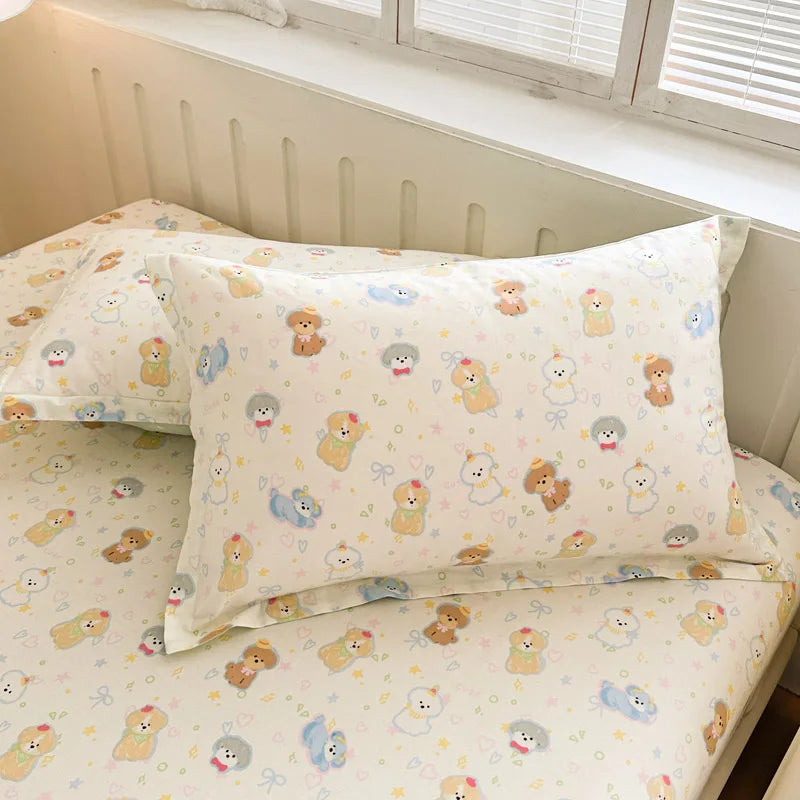 Lit d'enfant avec une parure de lit à motifs d'adorables chiots dans diverses poses et couleurs sur un fond beige clair.