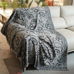 Couverture en tissu gris foncé avec un motif de formes abstraites et florales, créant un design élégant et sophistiqué pour un ameublement de salon ou de chambre.