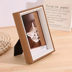 Cadre photo bois brun posé sur table en bois