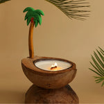 Une bougie décorée d'une petite palmier en bois, créant une ambiance tropicale et chaleureuse.