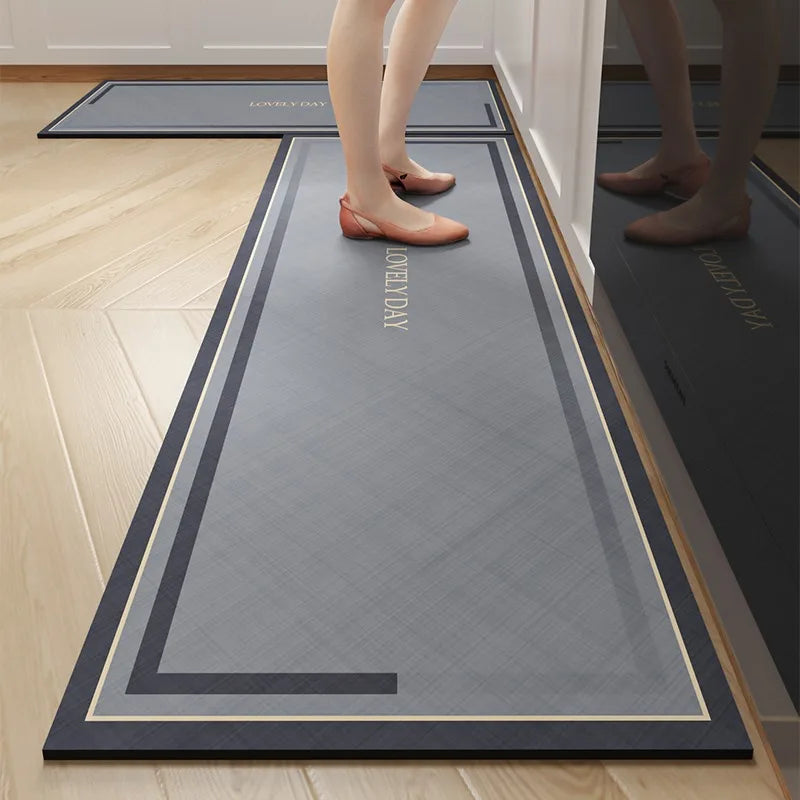 Un tapis d'entrée gris et noir avec des rayures décoratives, sur un sol en bois clair où l'on peut voir les pieds d'une personne portant des chaussures rouges.