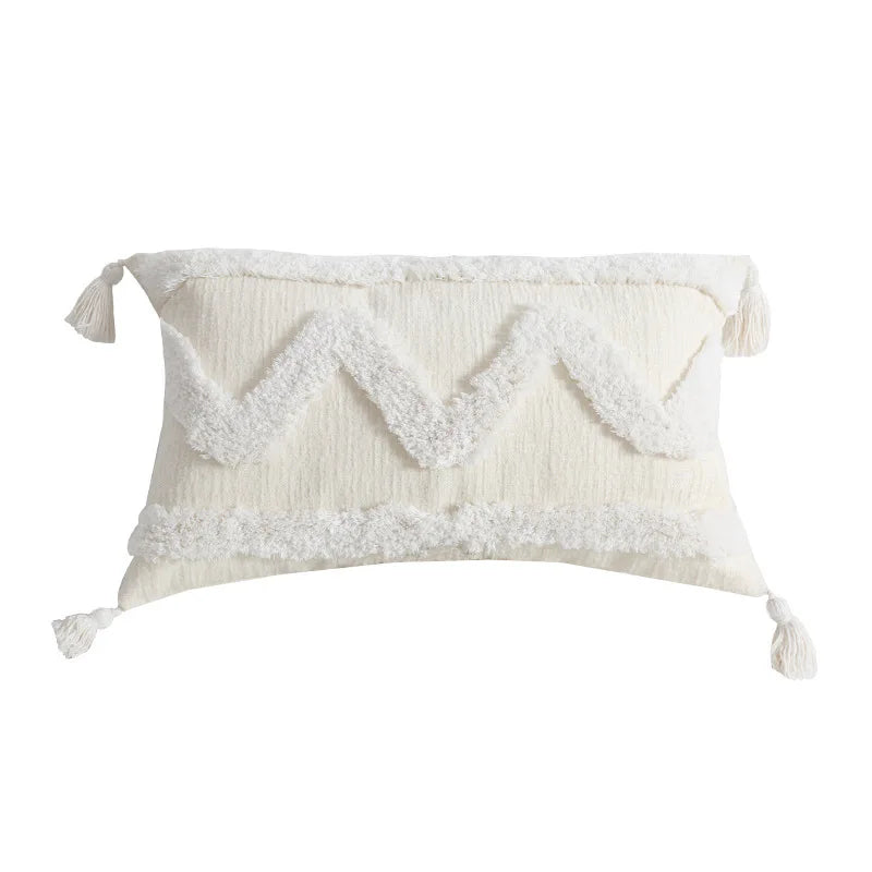 Coussin moelleux blanc orné de franges décoratif.