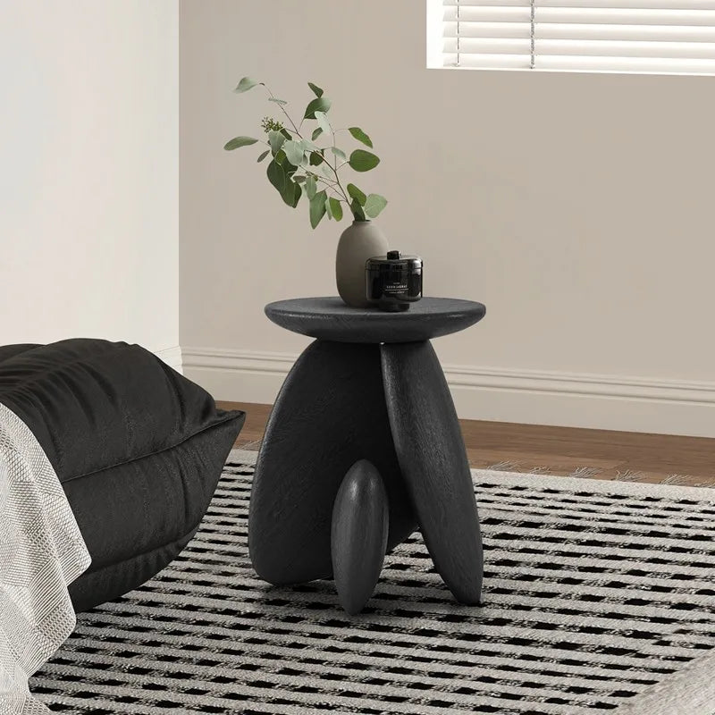 table basse ovale moderne vase branches fleurs bougie livres texture bois noir chambre coucher
