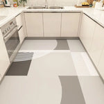 Cuisine moderne et élégante avec des comptoirs en granite blanc, des armoires beiges et un sol en carrelage aux motifs géométriques monochromes.