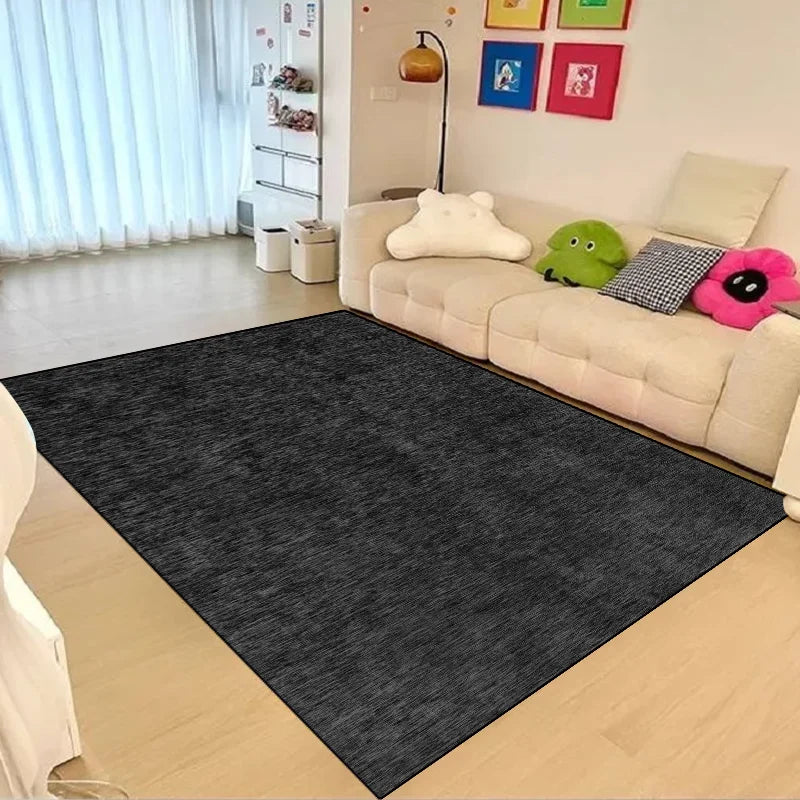 Un tapis en fibre naturelle gris foncé posé sur le sol dans un salon accueillant, avec des jouets colorés dispersés et des cadres artistiques accrochés au mur.
