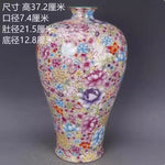 Un vase décoratif en porcelaine de forme élancée orné d'un motif floral coloré et éclatant, créant une pièce d'intérieur élégante et accrocheuse.