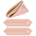 Serviette de table en satin rose pâle avec plis élégants, parfaite pour une table dressée avec goût.