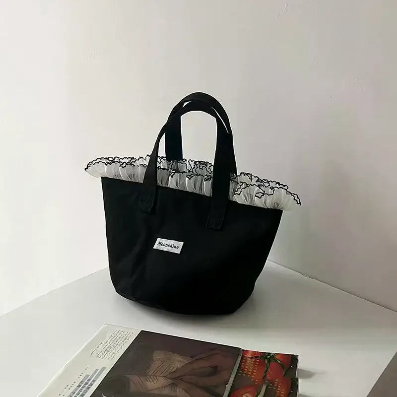 sac main femme noir texture veloutée moderne poignées étiquette logo