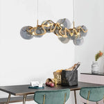 suspension lumineuse moderne transparente dorée ronds ondulés élégante chaînes suspendues ampoules métal