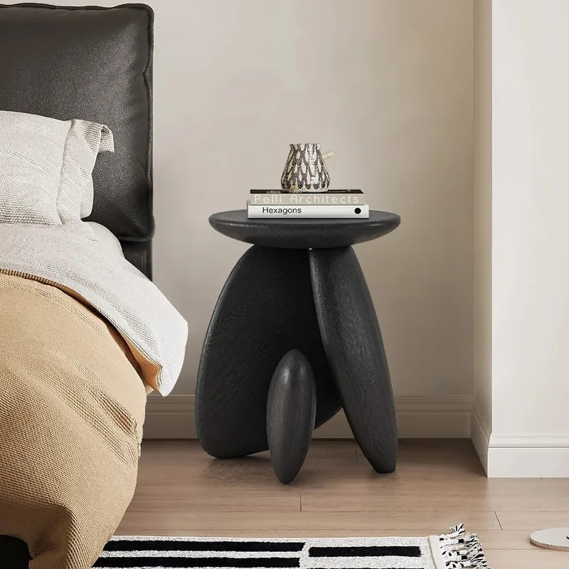 table basse ovale moderne vase branches fleurs bougie livres texture bois noir chambre coucher