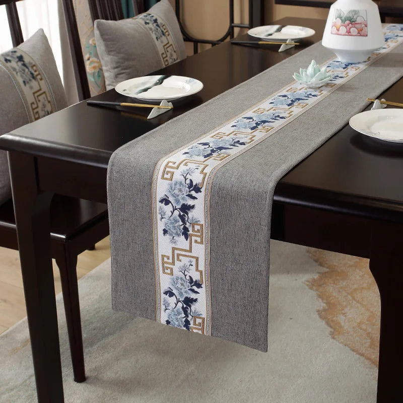 Ce chemin de table gris orné de motifs floraux et de motifs géométriques grecs est une élégante décoration de table.