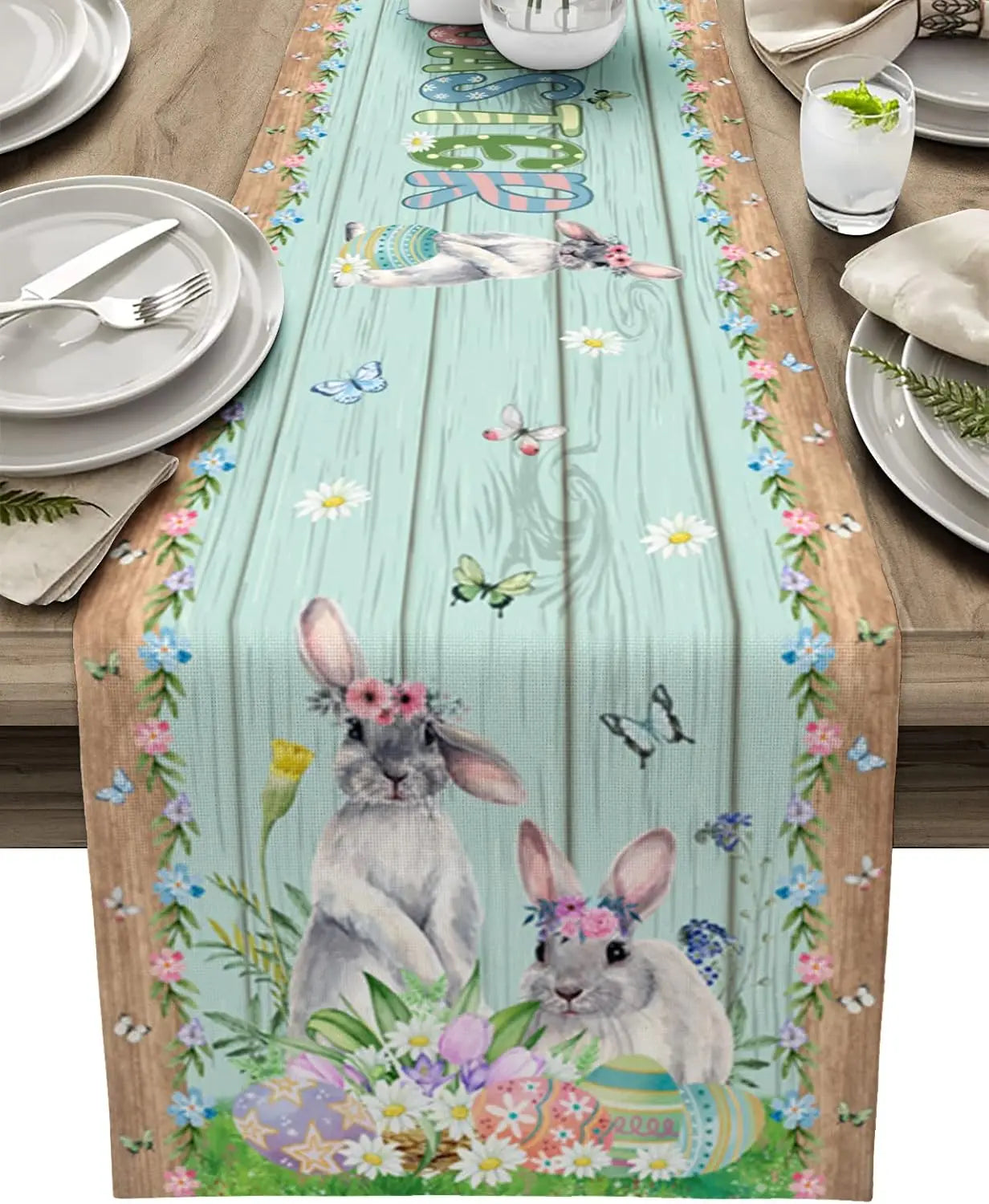 Chemin de table décoré de deux lapins mignons, d'œufs de Pâques et de fleurs printanières, sur fond de planches de bois.