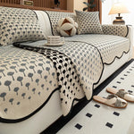 Une chambre à coucher élégante avec des coussins et un édredon ornés de motifs graphiques en noir et blanc, créant une ambiance chaleureuse et apaisante.