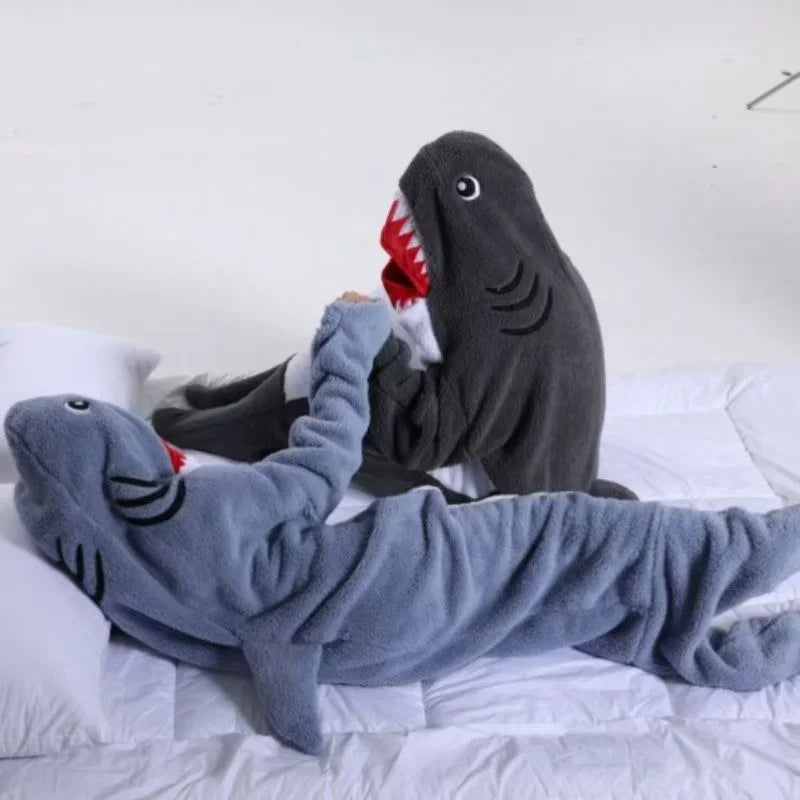 Cette image montre deux jouets en forme de requins gris avec de grandes gueules rouges qui semblent s'embrasser ou interagir de manière ludique.