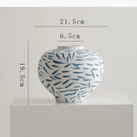 vase moderne blanc bleu rayures taches fleurs artificielles décoration intérieure unique table arrangement floral