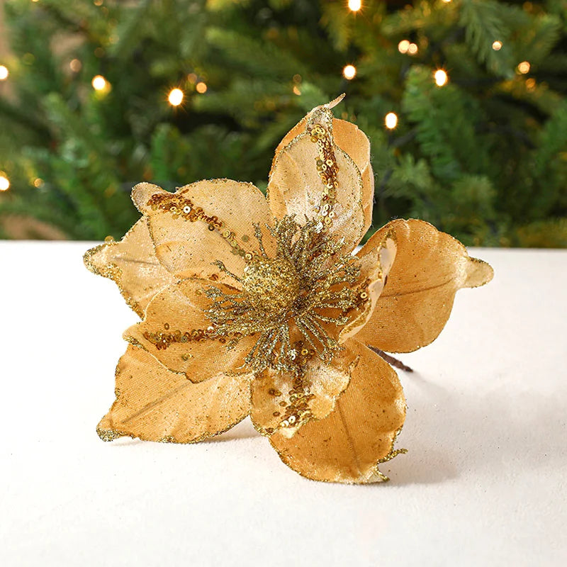 Fleur de Noël dorée posée sur une branche de sapin
