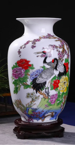 Magnifique vase décoratif en porcelaine blanche orné de motifs floraux colorés et d'une grue élégante.