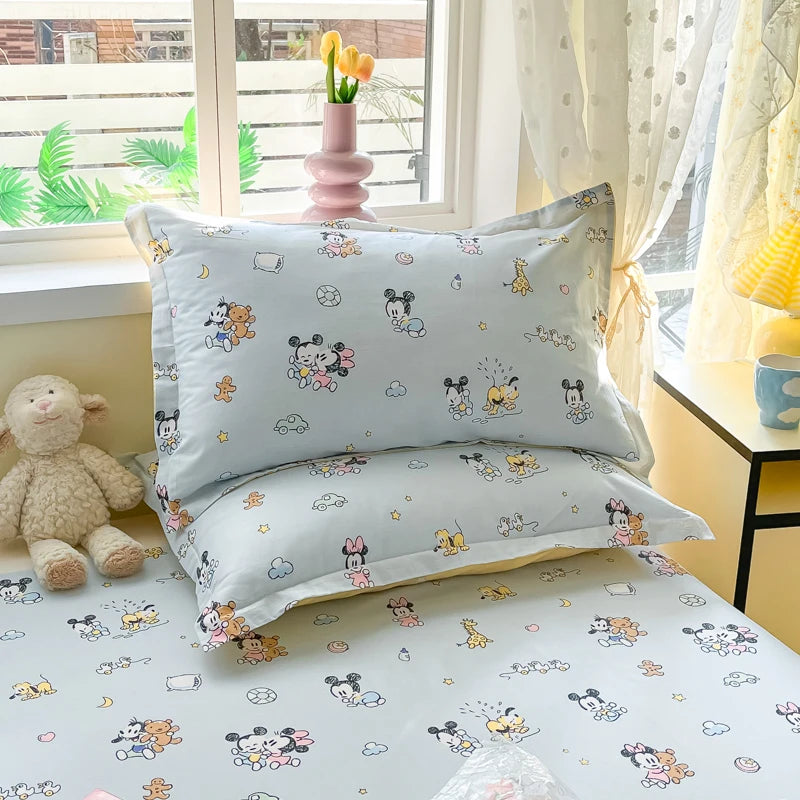 Une chambre d'enfant confortable avec des motifs de personnages de Disney imprimés sur les draps et les taies d'oreiller, créant une ambiance ludique et chaleureuse.