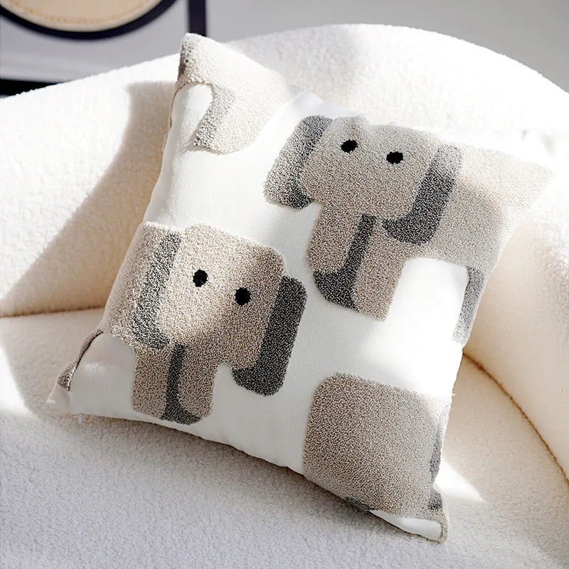 Coussin moelleux décoré de silhouettes d'éléphants, offrant une touche douce et apaisante à l'espace.