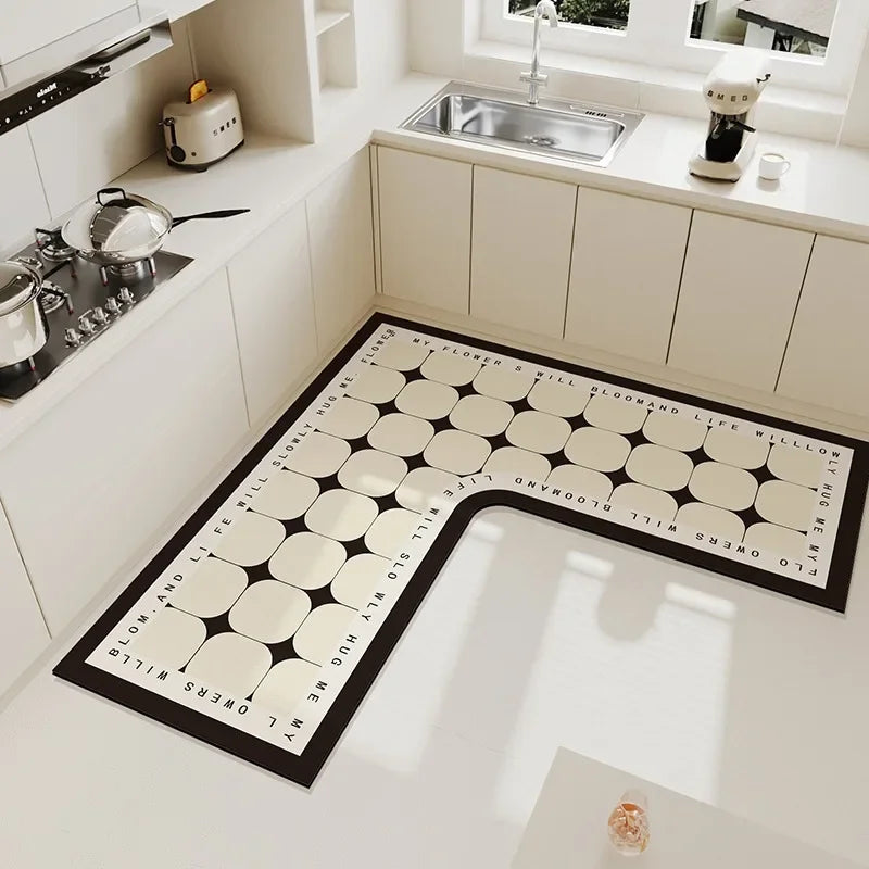 Un tapis de cuisine design à motifs géométriques noirs et blancs, qui ajoute une touche moderne et épurée à cette cuisine blanche équipée.