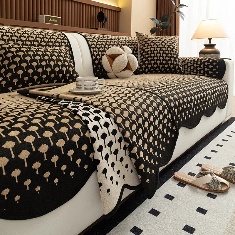 Un intérieur élégant avec un lit recouvert de coussins et de couvertures avec un motif graphique en noir et beige.