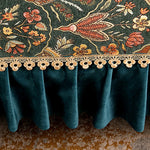 Rideaux en velours vert émeraude ornés de motifs floraux colorés et de bordures décoratives en forme de fleurs.