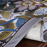 Le motif floral coloré et vibrant de ce textile met en valeur les détails et la texture du tissu, créant une atmosphère chaleureuse et accueillante.