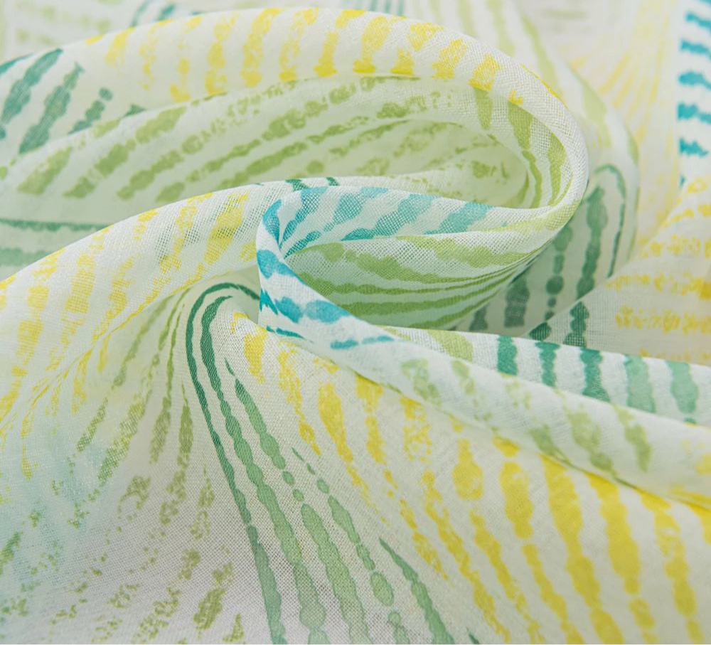 Version colorée vert et jaune du voilage grande largeur à ruflette dans un intérieur lumineux.