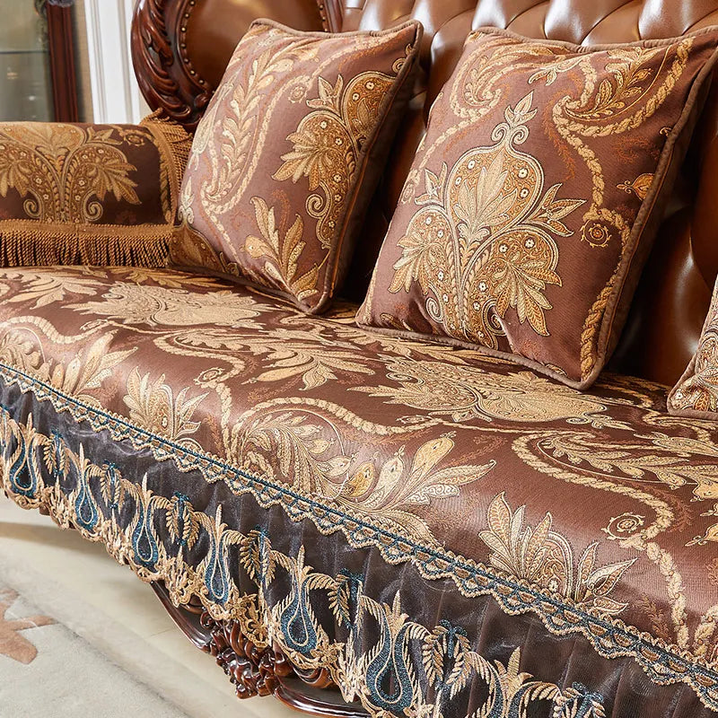 Un canapé exquis recouvert d'un tissu richement décoré de motifs floraux et de volutes dorées, créant une ambiance luxueuse et sophistiquée dans cet espace.