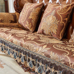 Un canapé exquis recouvert d'un tissu richement décoré de motifs floraux et de volutes dorées, créant une ambiance luxueuse et sophistiquée dans cet espace.