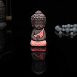 statuette bouddha artisanale couleur noir orange jaune bleu texture granulée méditatif argile violette