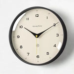 horloge murale quartz aiguille sourdine salon minimaliste visage unique fond blanc numéros noirs cadre