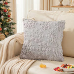 Un oreiller décoratif douillet gris clair orné de motifs texturés et posé sur un lit confortable dans un cadre cosy et féérique, complété de fruits colorés.