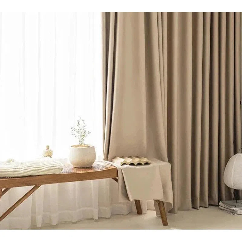 Rideaux occultants beige pour décoration intérieure moderne. Ces rideaux élégants, longs et drapés, apportent une touche raffinée à votre salon ou chambre à coucher, tout en offrant une excellente protection contre la lumière extérieure. Parfaits pour créer une atmosphère chaleureuse et accueillante dans votre maison.