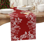 Un centre de table de Noël orné de décorations rouges et blanches festives comprenant des assiettes, des verres, des couverts et une couronne de Noël avec des baies.