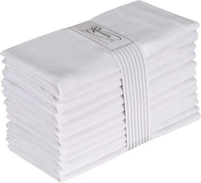 Une pile de serviettes en coton blanc pliées avec soin et une étiquette grise portant le logo de la marque.