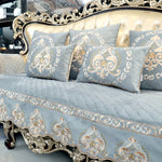 Canapé de luxe vintage recouvert de motifs décoratifs élégants en or et gris.