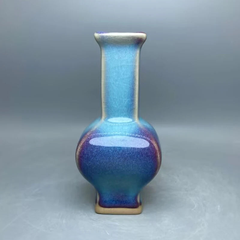 Un vase en céramique de couleurs bleu et violet, avec un col étroit et une forme élégante.