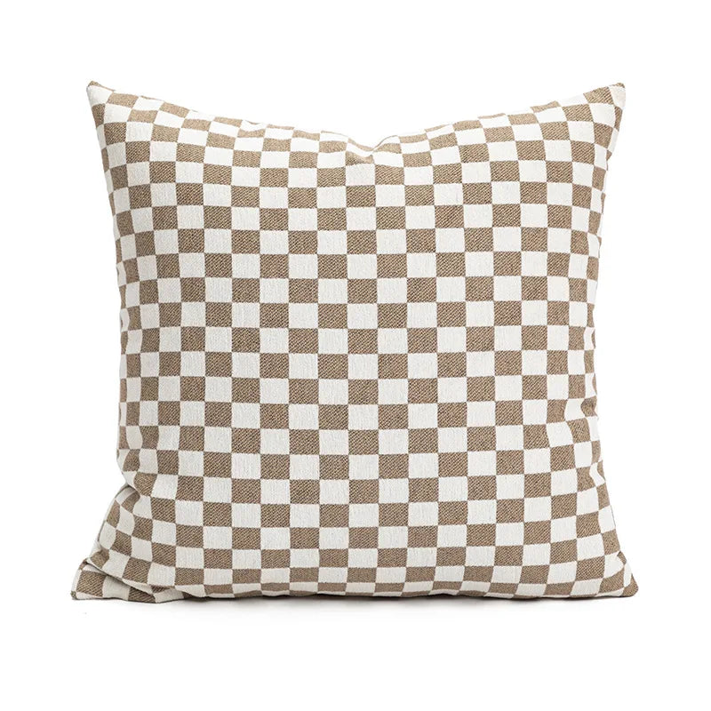 Coussin décoratif carré à motif damier beige et blanc.