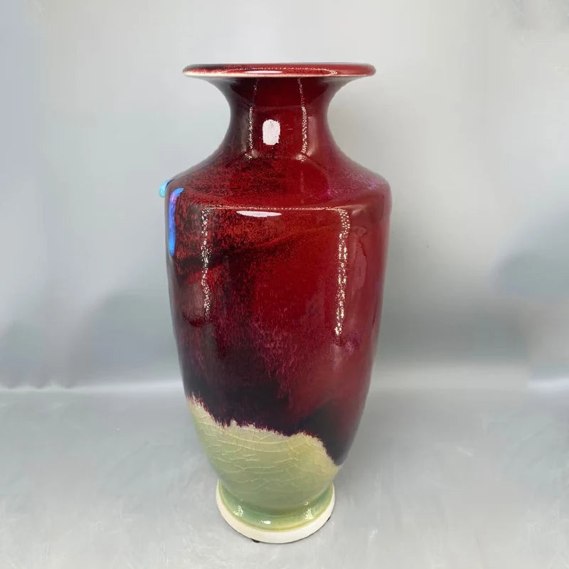Vase vintage en céramique de forme élégante avec un riche motif rouge et vert.