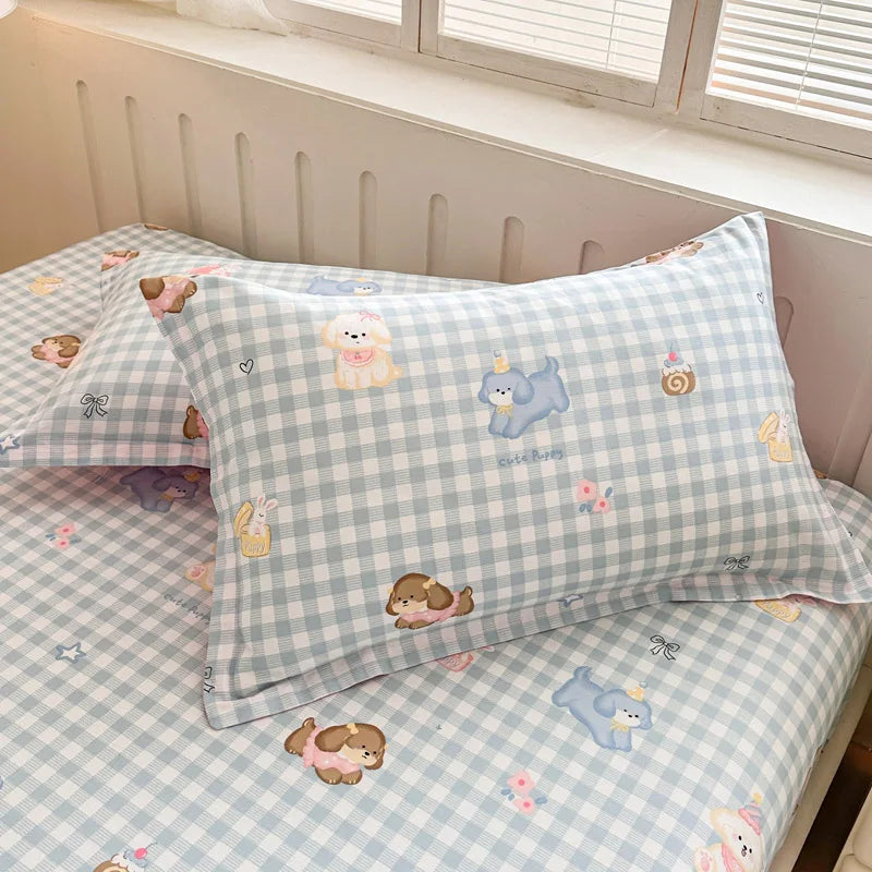 Ensemble de literie pour enfant avec motifs de chiots mignons et de petits animaux sur un fond à carreaux bleu clair et blanc.